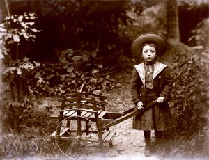 Niña con carrito en un jardín, principios del siglo XX