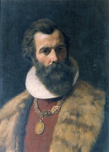 Hombre barbudo con cuello de piel y cadena.