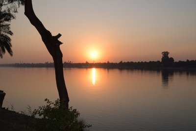 Reflejos dorados del atardecer en un río tranquilo de Albert Mansour