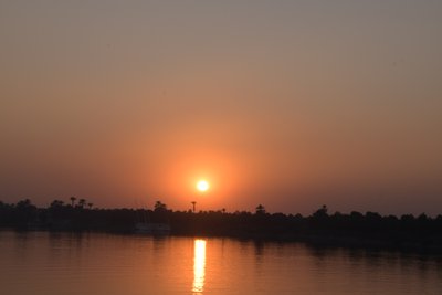 Reflejos dorados del atardecer en un río tranquilo de Albert Mansour