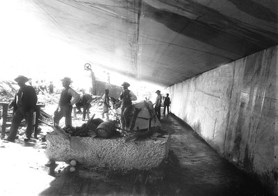 Excavadores bajo las paredes de mármol en una cantera, en los Alpes Apuanos (foto en blanco y negro) de A. Corsini