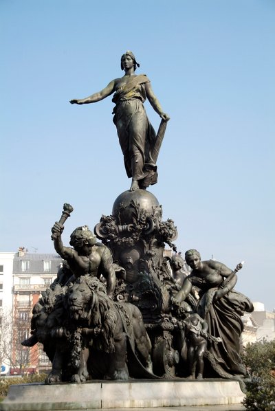 El tanque de la nación o triunfo de la República. Símbolo del sufragio universal. De pie sobre un tanque impulsado por dos leones (símbolo de la fuerza popular), Marianne está rodeada por las alegorías del Trabajo, la Justicia, la Paz y la Abundancia de Aime Jules Dalou