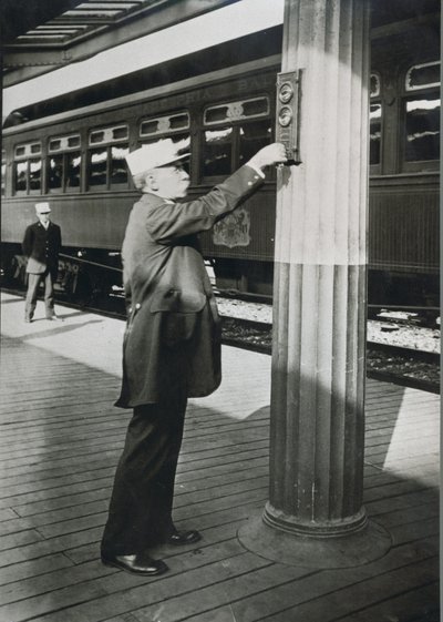 Un conductor señalando la salida inminente del tren 