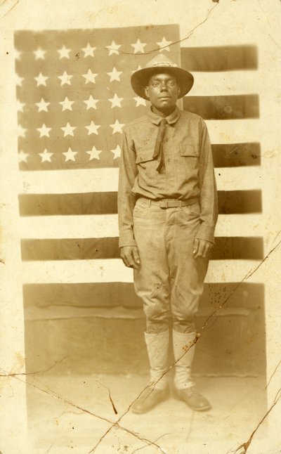 Soldado de la Primera Guerra Mundial con la bandera estadounidense en el fondo, 1914-18 de American Photographer