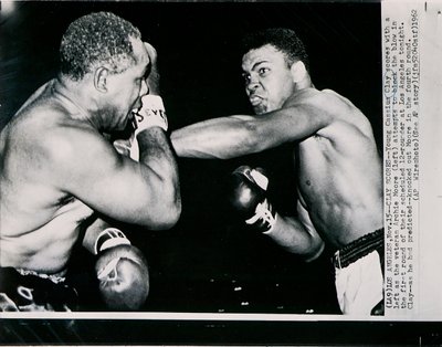El joven Cassius Clay golpea con la izquierda al veterano Archie Moore en el primer asalto de la pelea en Los Ángeles de American Photographer
