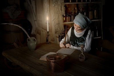 Mujer escribiendo a la luz de una vela de Andrzej Lisowski