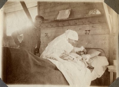 Primera Guerra Mundial 1914-1918: enfermera en bata afeitando a un soldado (herido de guerra francés en una cama), en Couville, Mancha, Baja Normandía, Francia. Fotografía anónima julio 1917. Colección privada, Stella. de Anonymous Anonymous