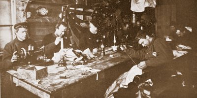 En la cabaña, en pleno invierno, los hombres se dedican a coser pieles para la ropa que se utilizará en la primavera en trineo, pub. Londres 1907 (foto en blanco y negro) de Anthony Fiala