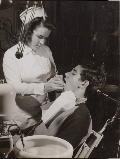 [Higienista dental inspecciona la boca de un paciente] de Arnold Eagle