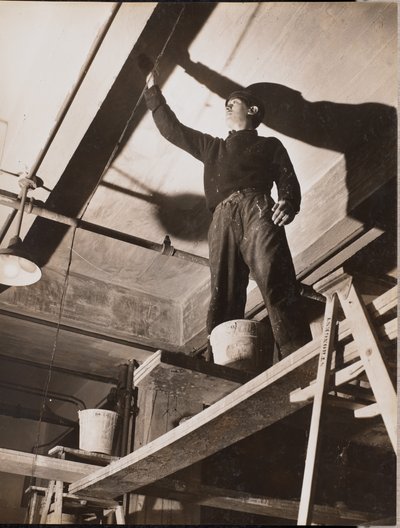 [Hombre de pie sobre un andamio de madera pinta un techo] de Arnold Eagle