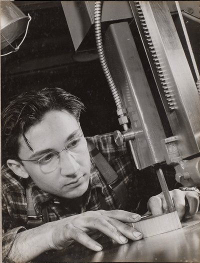 [Hombre con gafas trabaja atentamente con una lima industrial] de Arnold Eagle