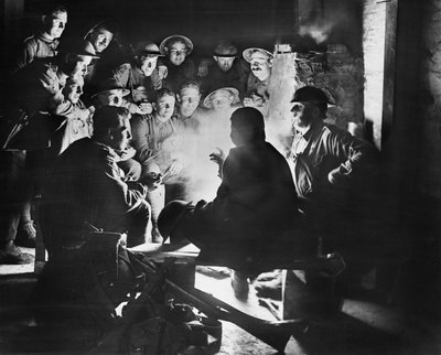 Miembros de la 1ª Batería de Morteros de Trinchera Ligera Australiana, 1ª División Australiana escuchando las últimas noticias de uno de sus camaradas alrededor de un fuego en un alojamiento en Ypres, 28 de octubre de 1917 de Australian Photographer