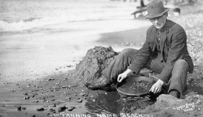 Hombre lavando oro en la playa, Nome, Alaska, c.1910 (foto en blanco y negro) de Brothers Lomen