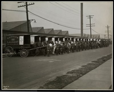 Carros de reparto tirados por caballos estacionados fuera de Carolyn Laundry en 111 East 128th Street, East Harlem, Nueva York, 1929 de Byron Company
