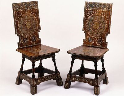 Un par de sillas de caoba con decoración floral incrustada de peltre y marfil de Carlo Bugatti