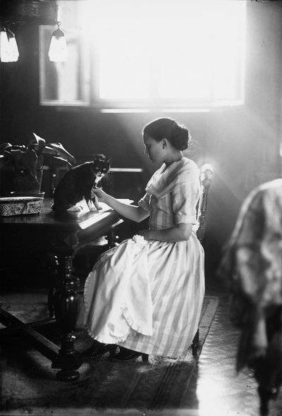 Retrato de Wanda sentada en una mesa con su gato, Trieste, c.1910 de Carlo Wulz