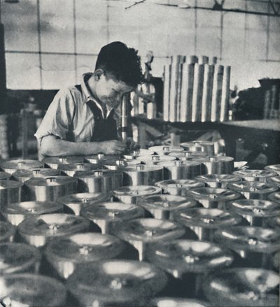 Aprendiz con microscopio probando la dureza de los pistones, 1941 de Cecil Beaton