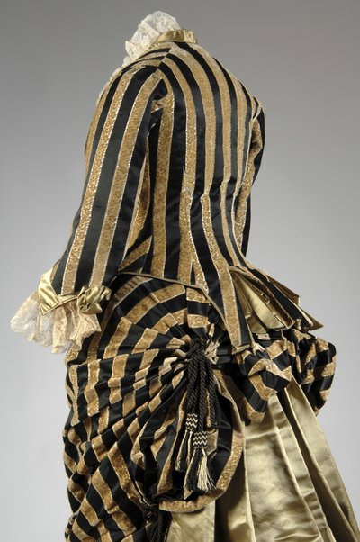 Vestido de noche, c.1884 (vista parcial oblicua trasera). Satén de seda y terciopelo cortado, encaje, borlas y flecos de hilo de seda. Charles Frederick Worth, Francia. de Charles Frederick Worth