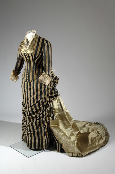 Vestido de noche, c.1884 (vista oblicua lateral). Satén de seda y terciopelo cortado, encaje, borlas y flecos de hilo de seda. Charles Frederick Worth, Francia. de Charles Frederick Worth