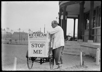Un vendedor de helados Eldorado junto a su carrito de triciclo fuera de un pabellón, 1930s de Charles William Prickett