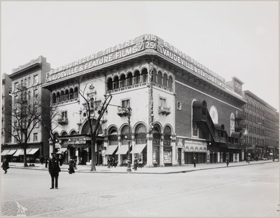 Un gran teatro con una fachada elaborada, completa con arcos moriscos y balcones. Un gran cartel en la parte superior del edificio dice 