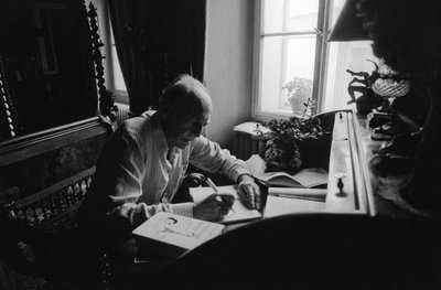 Jiri Mucha sentado en su escritorio en su casa en Hradcany, Praga de Czech Photographer