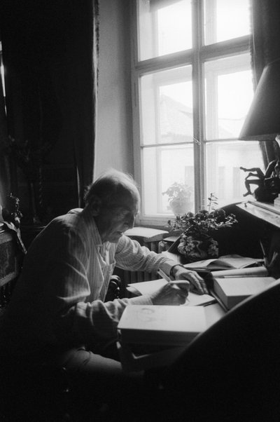 Jiri Mucha sentado en su escritorio en su casa en Hradcany, Praga de Czech Photographer