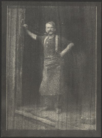 [Herrero de pie en la puerta, pipa en la boca] de Doris Ulmann