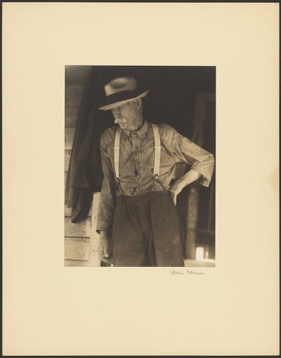 [Viejo bigotudo con sombrero de paja y tirantes de pie en la puerta] de Doris Ulmann