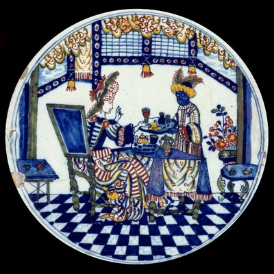 Plato de porcelana de Delft que representa a una mujer en una mesa servida por su sirviente negro. 1705 Sèvres, Museo Nacional de Cerámica de Dutch School