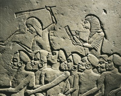 Un grupo de prisioneros negroides rodeados por guardias armados con porras mientras un escriba redacta un informe. Relieve de la tumba de Horemheb en Saqqara, detalle de Egyptian 18th Dynasty