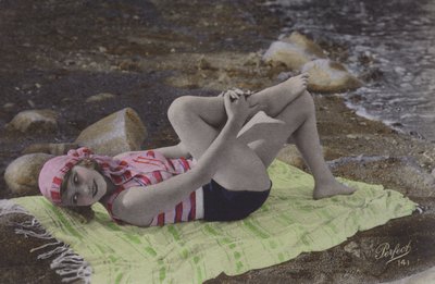 Chica tumbada en toalla en la playa de English Photographer