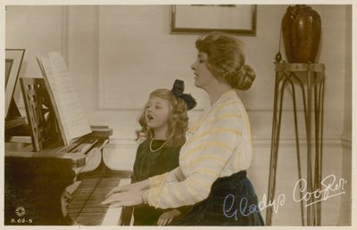 Gladys Cooper y niña en el piano de English Photographer