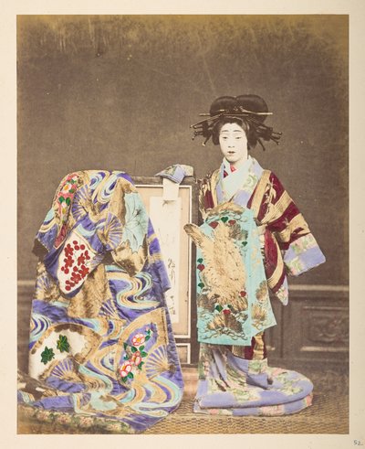 Mujer japonesa con traje tradicional, ] Retrato de estudio de pie de cuerpo entero de una mujer que lleva un traje y un peinado elaborados, con otra túnica sobre el marco a su lado,  Fotógrafo: Desconocido  Colección Lucas: Registro fotográfico de la w de English Photographer