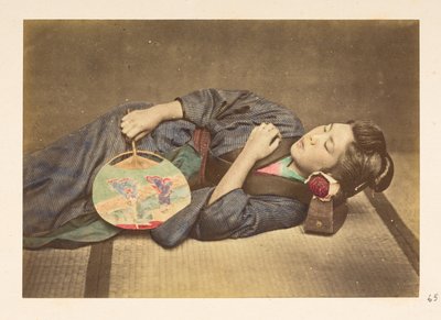 mujer japonesa durmiendo, Retrato de estudio de tres cuartos de longitud de una joven japonesa durmiendo, sosteniendo un ventilador en la mano derecha y con la cabeza apoyada en una almohada de madera,   Fotógrafo: Desconocido  Colección Lucas: Registro fo de English Photographer
