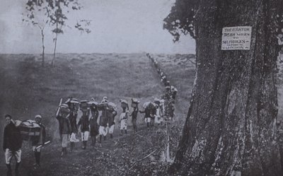 Fila de hombres llevando mercancías desde el ecuador hasta Selfridges, Londres de English Photographer
