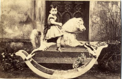 Niña pequeña en un gran caballo mecedor en un jardín, 1860s de English Photographer