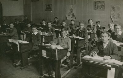 Alumnos varones sentados detrás de sus escritorios durante una lección en la escuela de English Photographer