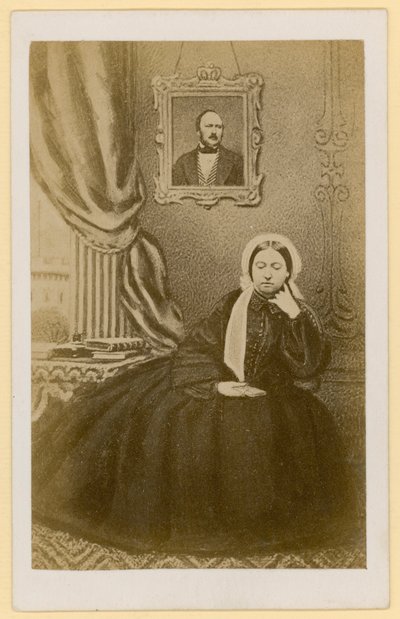 Reina Victoria, cuando era viuda, con un retrato del Príncipe Consorte detrás de ella de English Photographer