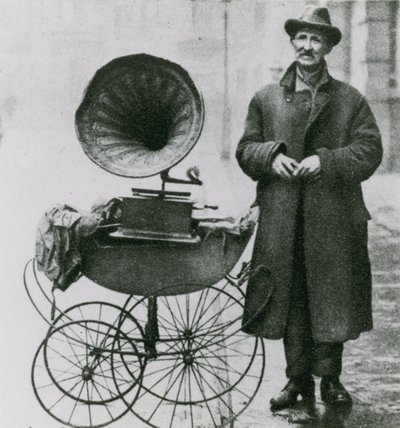 Fotografía sin título de hombre con un fonógrafo en un cochecito de English Photographer