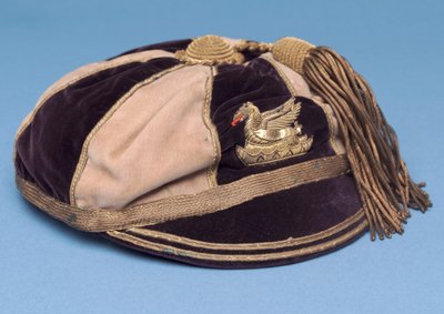 Gorra de fútbol segmentada azul y blanca con insignia de dragón de metal y borla dorada de English School