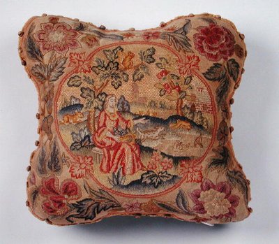 Cojín, bordado en petit point, que representa a una mujer en un paisaje de English School
