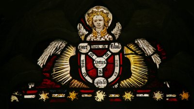 Ventana Ew que representa un ángel con un escudo de la Trinidad de English School