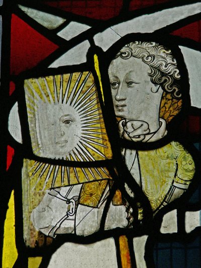Ventana S5 que representa a un ángel con una bandera con el sol y una cara de English School
