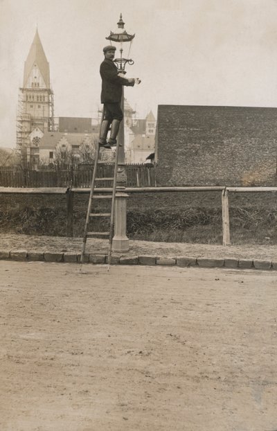Hombre en una escalera arreglando una lámpara de calle de European Photographer