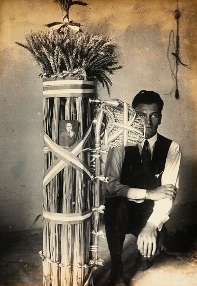 Antonio Floridi posando cerca de fasces de lictores hechos de espigas de trigo. Granja propiedad de Camillo Frizzoni, en Morengo, provincia de Bérgamo. En la parte superior de los fasces hay una foto de Mussolini de F. Frizzoni