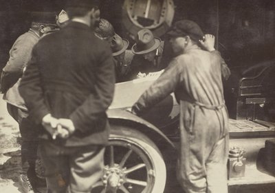 [Hombres agrupados alrededor del capó de un coche] de Fedele Azari