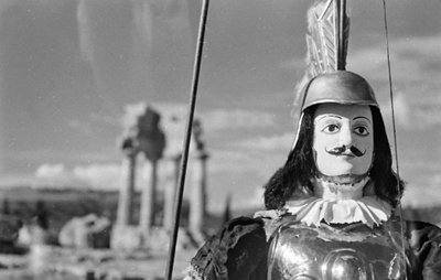 Marioneta siciliana. Al fondo, el Templo de Cástor y Pólux o de Cástor y Pólux en el Valle de los Templos de Agrigento. de Fosco Maraini