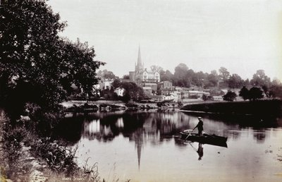 La ciudad de Ross-On-Wye, vista desde una orilla del río. En primer plano un hombre de pie en un bote de remos de Francis Frith