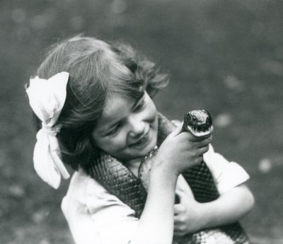 Una niña, Betty, sosteniendo una serpiente índigo oriental, Zoológico de Londres, 1924 de Frederick William Bond